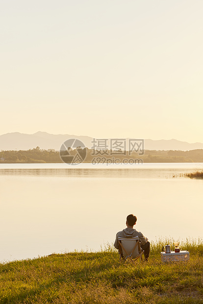 男青年户外湖边享受生活背影图片