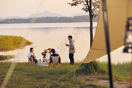 夏天夜晚年轻人傍晚在湖边聚会聊天背景