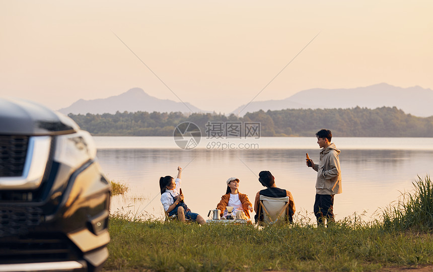 年轻人傍晚在湖边聚会聊天图片