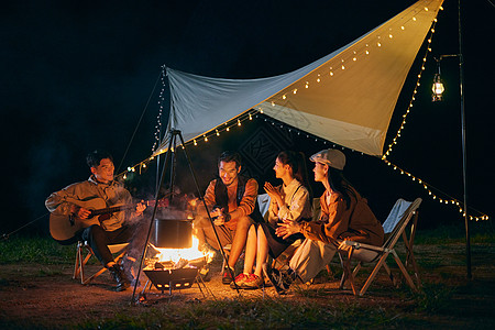 年轻人夜晚露营篝火派对背景图片