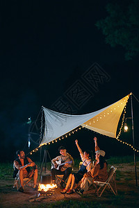 年轻人夜晚露营篝火派对背景图片