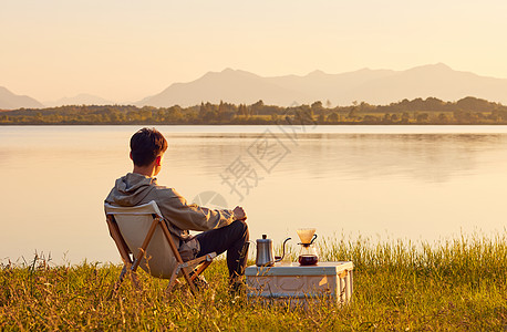 秋天湖边年轻男生湖边享受阳光背影背景