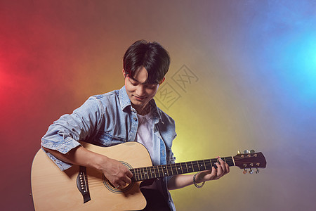 多彩创意男性歌手坐着弹吉他背景图片