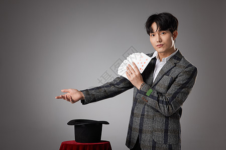 男性魔术师正在变纸牌魔术图片