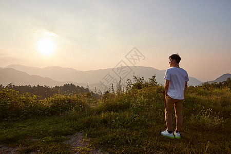 男生旅行中的背影年轻男生山顶看落日背影背景