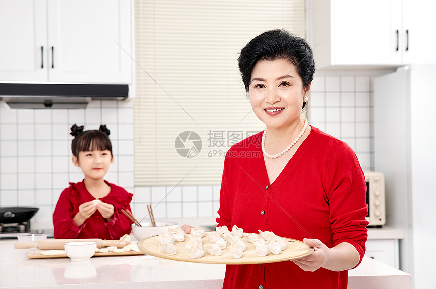 厨房里奶奶端着包好的饺子图片