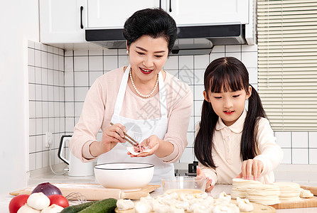 奶奶与孙女厨房里一起包饺子图片