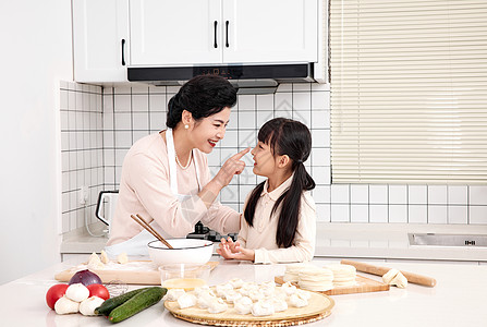 温馨居家奶奶与孙女厨房里一起包饺子背景