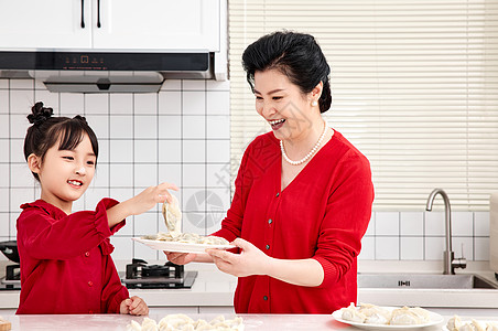 厨房里奶奶端着煮好的饺子高清图片