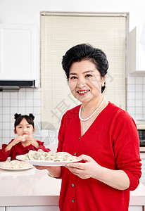 厨房里奶奶端着煮好的饺子图片