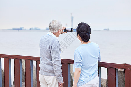 走路老年夫妇江边户外散步背影背景