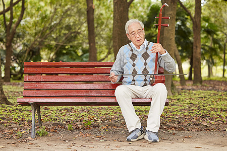 男性老人在长椅上拉二胡唱歌背景图片