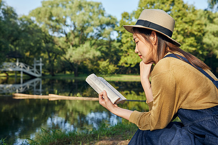 秋天湖边美女公园郊游看书阅读背景