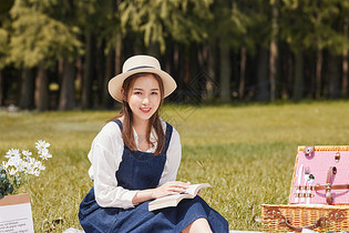 青年女性公园户外野餐阅读图片