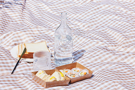 野餐垫上的饮料和面包图片