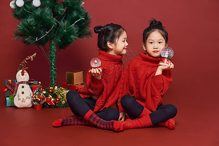 双胞胎小女孩过圣诞节拿水晶球图片