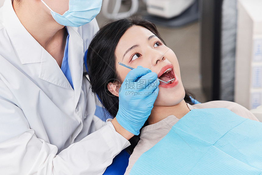 牙科医生为患者检查牙齿特写