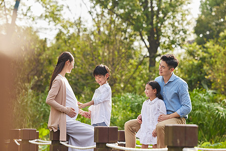 夫妻怀孕三胎夫妻带着孩子湖边散步背景