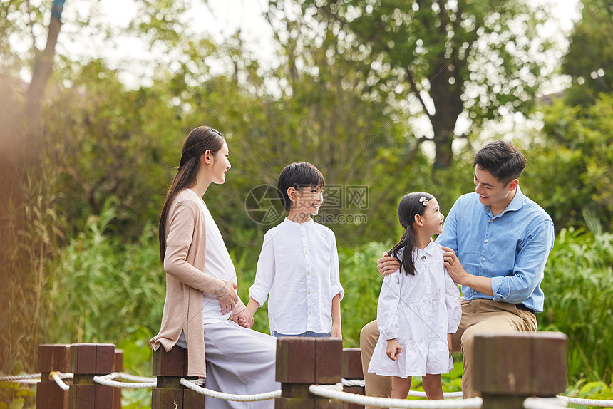 三胎夫妻带着孩子湖边散步图片