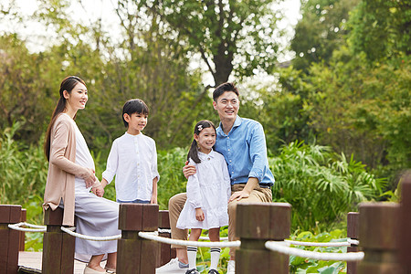 三胎夫妻带着孩子湖边散步图片