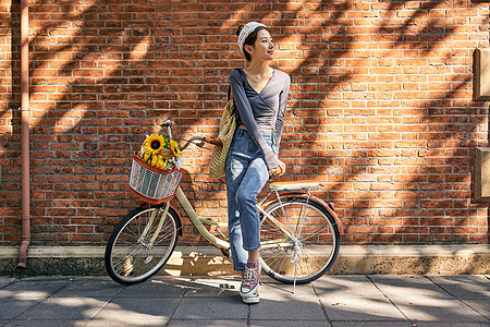 温暖阳光清新美女骑自行车出游逛街背景