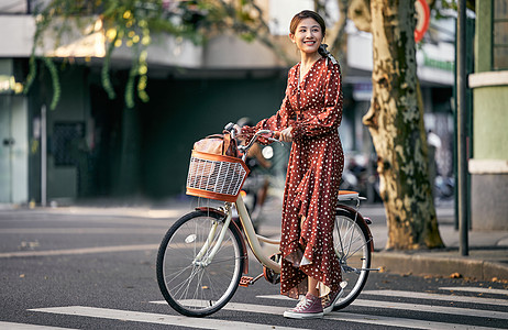 清新美女出游推着自行车过马路图片