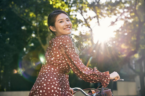 清新美女坐在自行车上回眸一笑图片