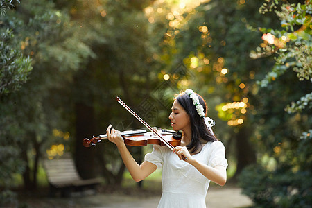 艺用美女素材夕阳余晖中拉小提琴的少女背景