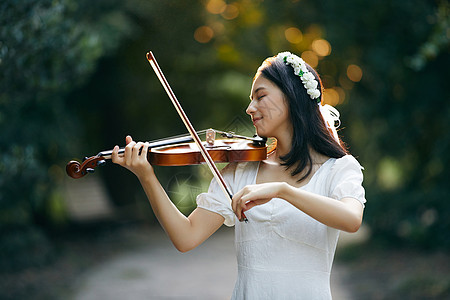 森林中的美女公主夕阳余晖中拉小提琴的少女背景