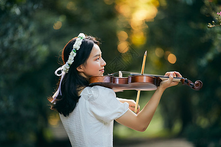 森林中的美女公主夕阳余晖中拉小提琴的少女背景