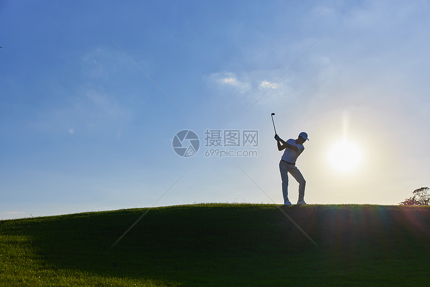 阳光下打高尔夫的男性剪影图片