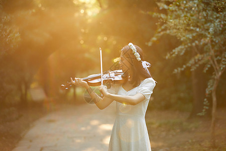 艺用美女素材夕阳余晖中拉小提琴的少女背景