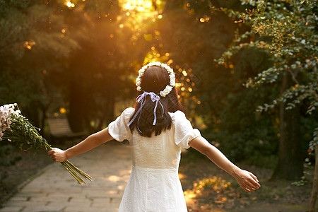 枫树下少女夕阳下拿着花的少女背影背景