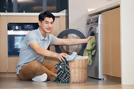 家用洗衣机年轻男性居家使用洗衣机洗衣服背景
