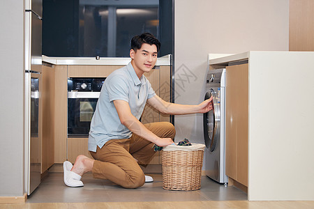年轻男性居家调试洗衣机图片
