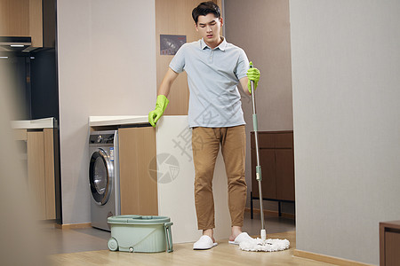 年轻男性居家打扫卫生疲惫图片