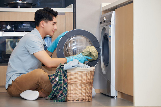 男青年居家使用洗衣机洗衣服图片