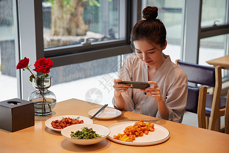 手机记录青年女性吃饭用手机拍照记录美食背景