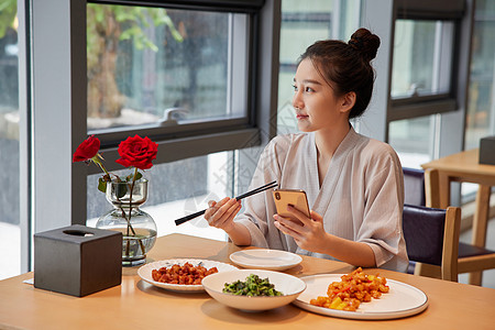 青年美女在汤泉馆美食区吃饭玩手机背景