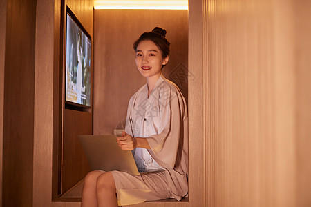 女性养生青年女性在汤泉休息区使用电脑背景