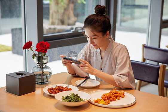 青年美女在汤泉馆美食区享用美食图片