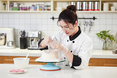 女性烘焙师装饰蛋糕高清图片