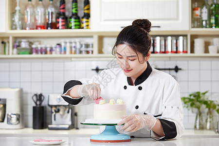 青年女西点师装饰蛋糕图片