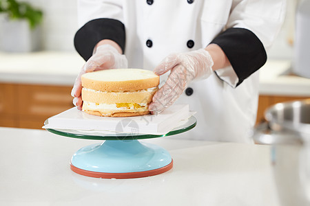 美女手端蛋糕女性烘焙师制作蛋糕特写背景
