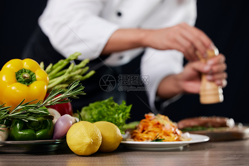 厨师给食物调味特写图片