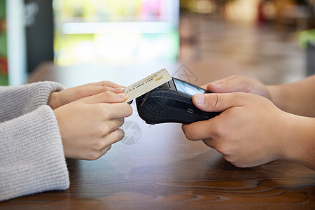 信用卡刷卡青年女性超市购物POS机刷卡付款特写背景