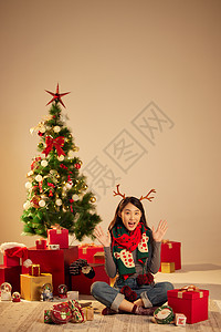 清纯可爱美女圣诞节开心的坐在圣诞树和礼物前图片
