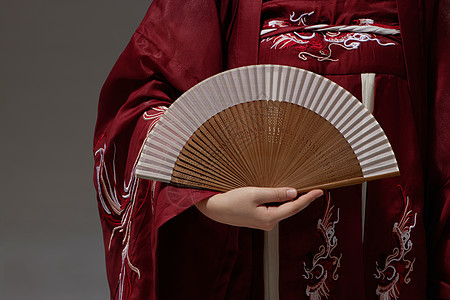 中国扇子穿着汉服的女生手里拿着折扇背景