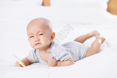 可爱婴儿宝宝手拿玩具哭泣图片