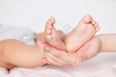 妈妈手托新生婴儿的小脚特写图片